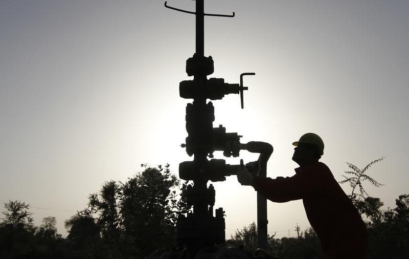 © Reuters. Рабочий крутит вентиль на газовой станции ONGC близ Ахмедабада