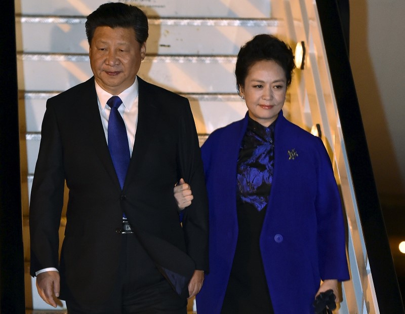 © Reuters. Chinese President Xi Jinping and his wife Peng Liyuan arrive for a four-day state visit at London's Heathrow Airport