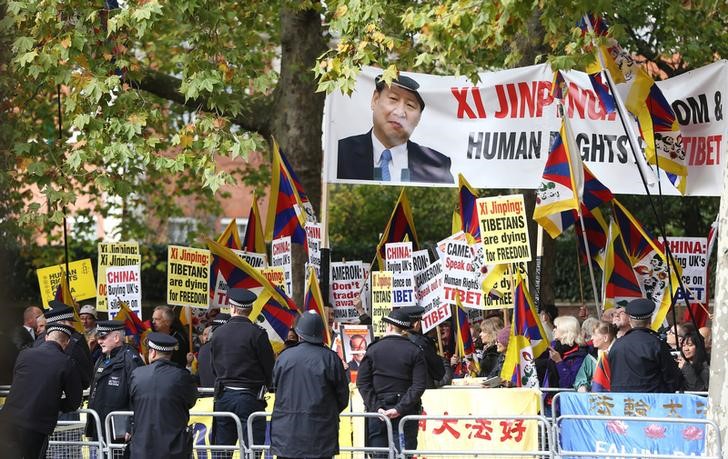 © Reuters. Policiais e manifestantes durante chegada do presidente da China, Xi Jinping, à Grã-Bretanha