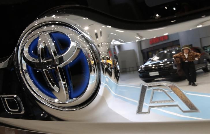 © Reuters. A visitor is reflected in a logo of Toyota Motor Corp at the company's showroom in Tokyo