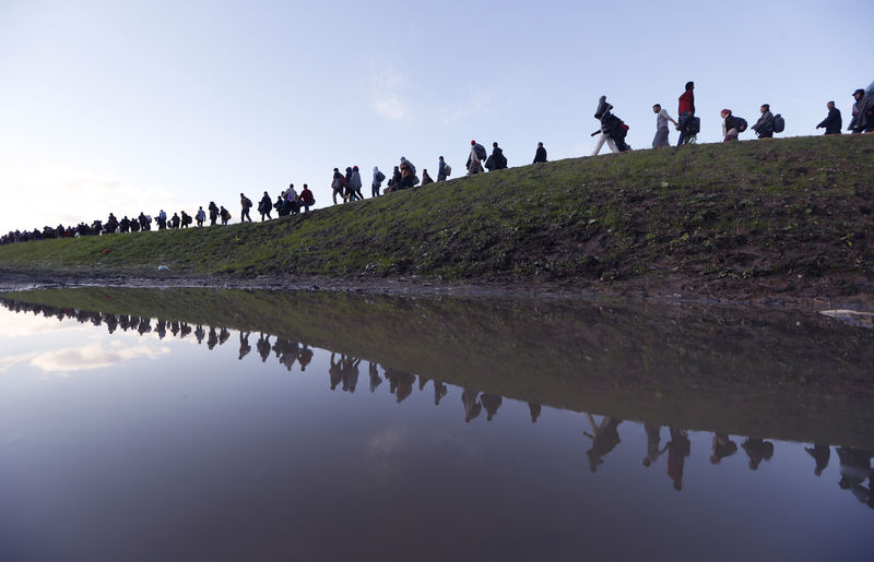 © Reuters. Migrants make their way on foot on the outskirts of Brezice