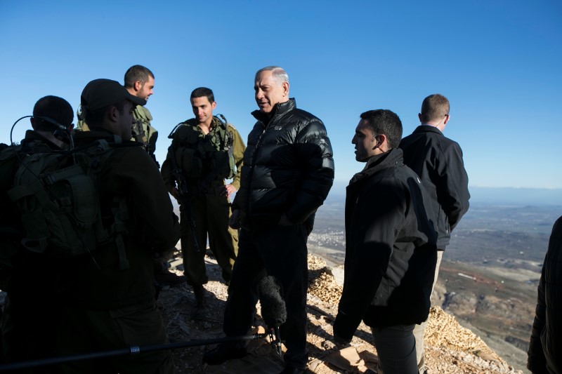 © Reuters. Benjamin Netanyahu chats with Israeli soldiers at a military outpost during a visit to Mount Hermon in the Golan Heights over looking the Israel-Syria border