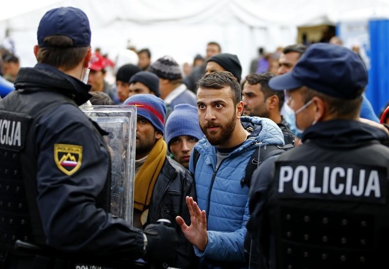 © Reuters. Imigrantes e policiais na cidade de Sentilj, na Eslovênia