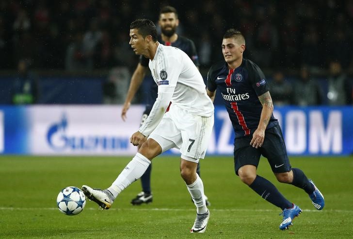 © Reuters. Cristiano Ronaldo (E), do Real Madrid, domina  a bola diante de Marco Verratti (D) do Paris St. Germain durante partida pela Liga dos Campeões em Paris