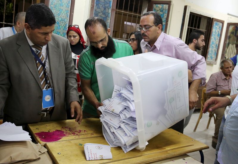 © Reuters. Funcionários contam cédulas após as votações se encerrarem na primeira fase das eleições parlamentares em um centro de votações em Dokki, Giza 