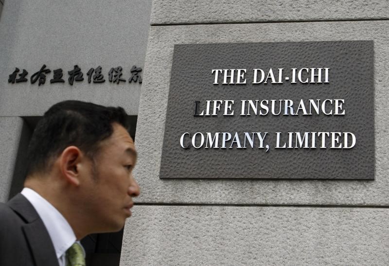 © Reuters. A man walks past the new signboard of Dai-Ichi Life Insurance Company Limited at its headquarters in Tokyo