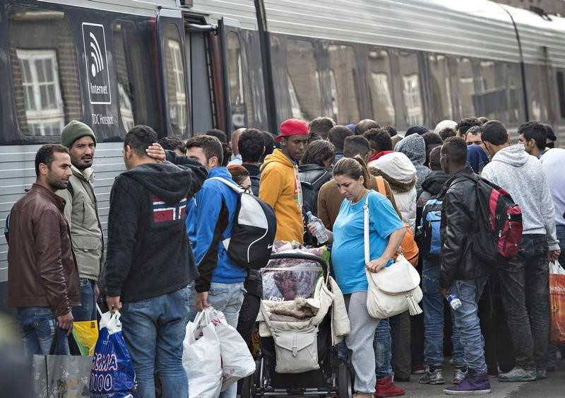 © Reuters. Imigrantes embarcando em trem para Suécia, em estação na Dinamarca