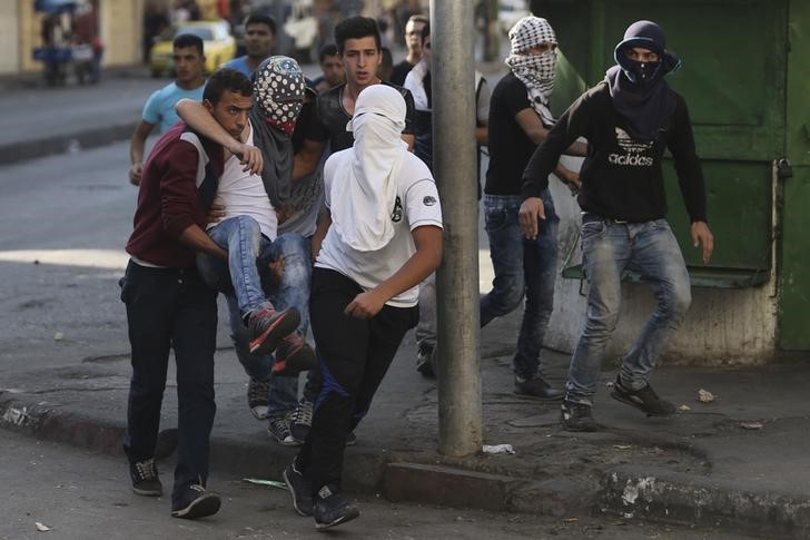 © Reuters. Manifestantes palestinos durante confronto contra tropas israelenses, em Hebron, na Cisjordânia