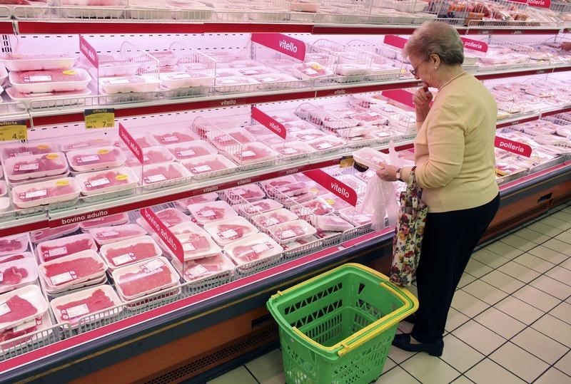 © Reuters. Milano, cliente in un supermercato al banco carni