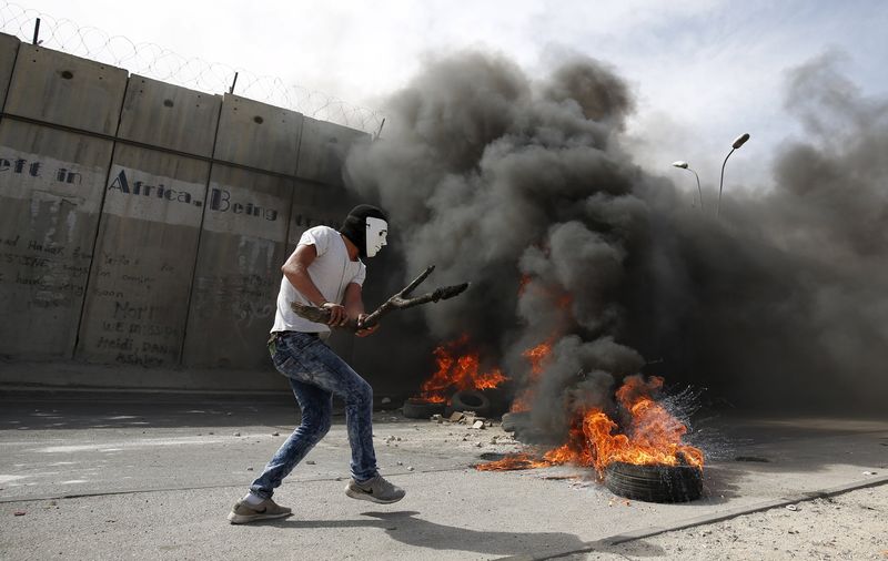 © Reuters. Manifestante palestino usando atiradeira contra barreira israelense em Al-Ram, na Cisjordânia