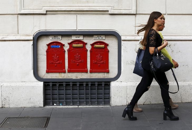 © Reuters. Women walk past mailboxes in central Rome