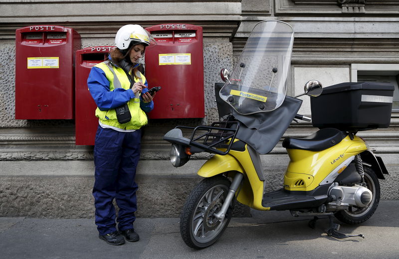 © Reuters. A postwoman use her device in front of headquater of Poste Italiane downtown Milan