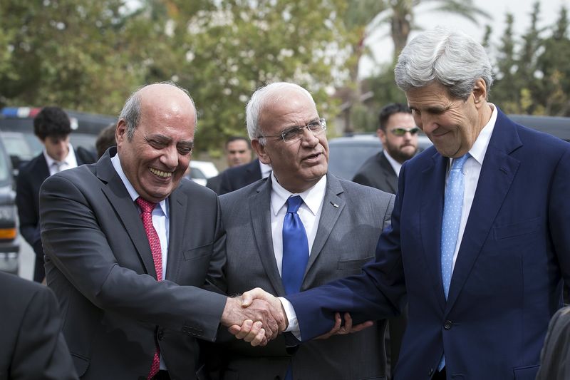 © Reuters. U.S. Secretary of State John Kerry shakes hands with an official as he arrives for a meeting with Palestinian President Mahmoud Abbas at Abbas' residence in Amman