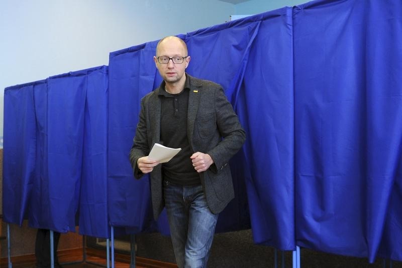 © Reuters. Yatseniuk walks out of a voting booth during a regional election at a polling station in Kiev