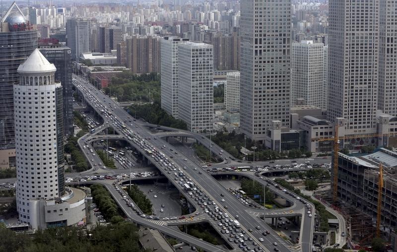 © Reuters. Vehicles drive on the Guomao Bridge through Beijing's central business district