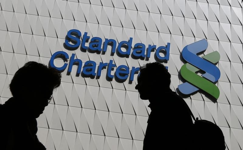 © Reuters. Passersby walk in front of the main branch of Standard Chartered in Hong Kong