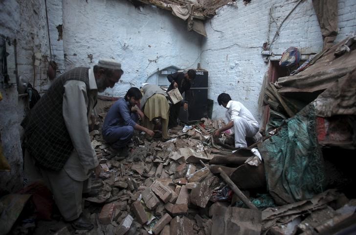 © Reuters. Moradores procuram pertences no meio de escombros após forte terremoto em Peshawar