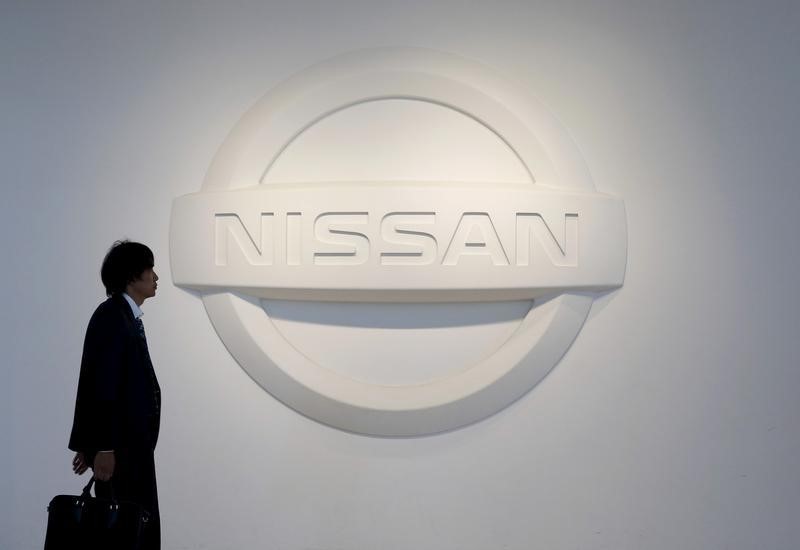 © Reuters. A man walks past the logo of Nissan Motor Co. at the company's showroom in Yokohama