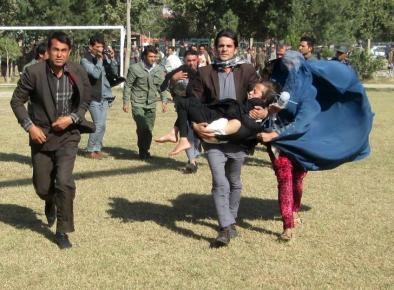 © Reuters. A man carries an injured girl to a military helicopter after an earthquake in Taloqan, Afghanistan