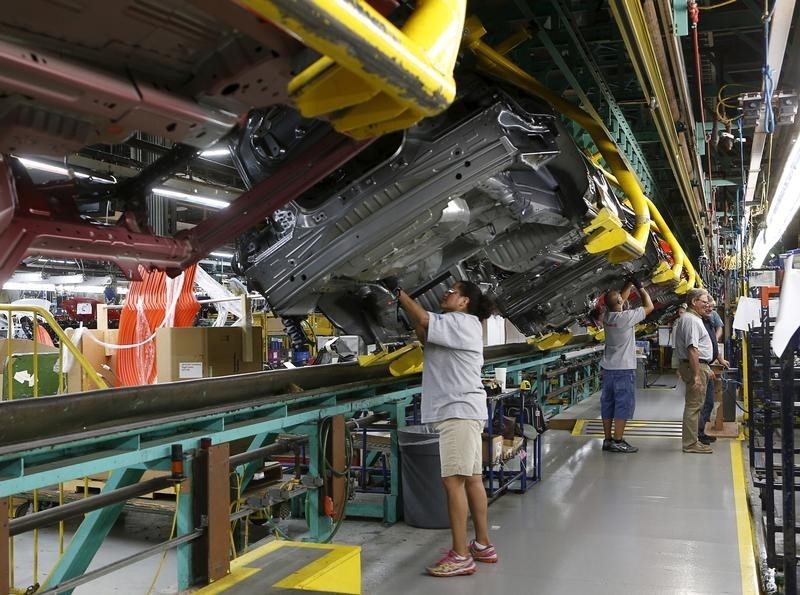 © Reuters. Assembly workers work on the underside of 2015 Ford Mustang vehicles on the production line at the Ford Motor Flat Rock Assembly Plant in Flat Rock, Michigan,