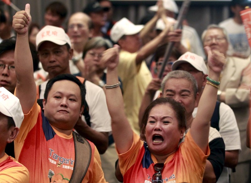 © Reuters. Supporters of People First Party (PFP) Chairperson James Soong gesture during a news conference in Taipei