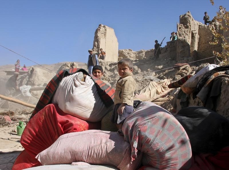 © Reuters. Children stand by their belongings after an earthquake, in Keshem district of Badakhshan province, Afghanistan