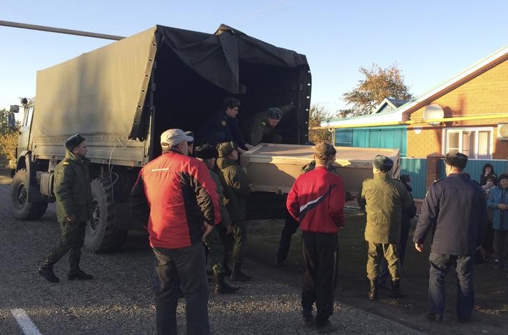 © Reuters. Russian servicemen unload a coffin containing the body of Kostenko from a truck near his family's house in the village of Grechnaya Balka