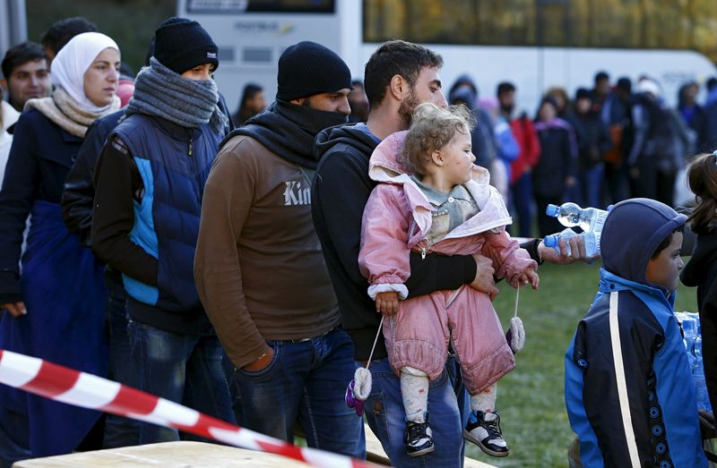 © Reuters. Migrants stay in queue after arriving at Austrian-German border in Wegscheid