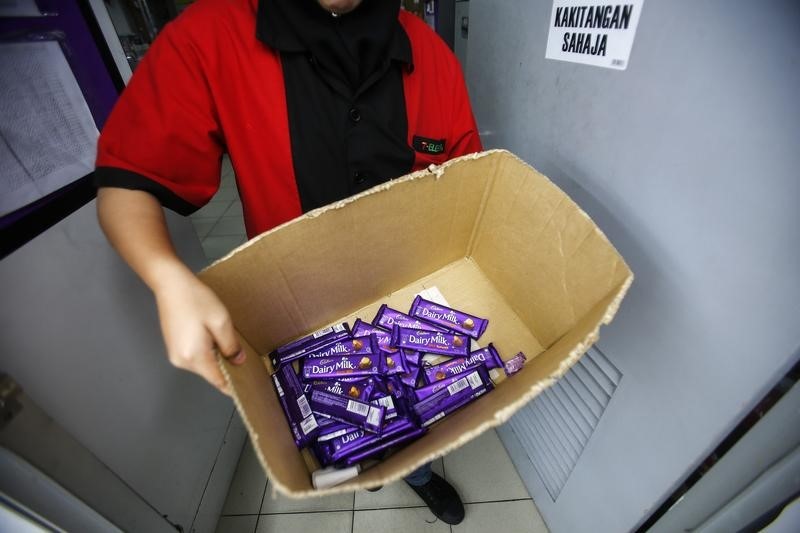 © Reuters. An employee shows a box containing Cadbury Dairy Milk Hazelnut and Cadbury Dairy Milk Roast Almond, to be return tomorrow in a shop in Shah Alam