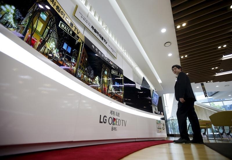 © Reuters. An employee stands in front of LG Electronics' television sets, which are made with LG Display flat screens, at its store in Seoul, South Korea