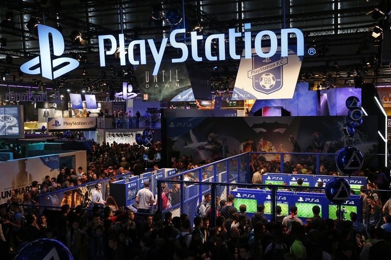 © Reuters. Visitors play games on PlayStation 4 (PS4) at the Paris Games Week, a trade fair for video games in Paris