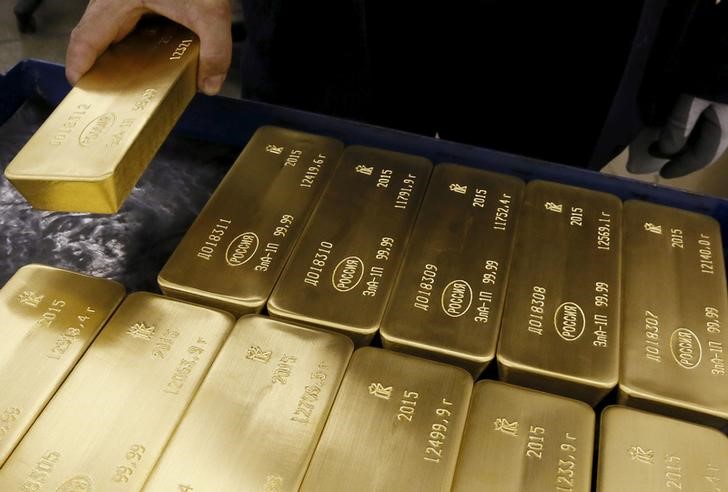 © Reuters. Работник завода Красцветмет кладет в ящик слитки золота