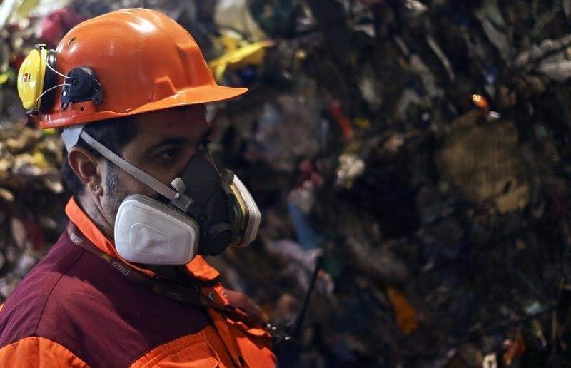 © Reuters. Roma, un operatore dell'azienda comunale per i rifiuti al lavoro in un impianto di trattamento