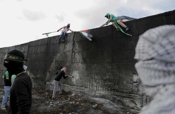 © Reuters. Manifestantes palestinos durante confronto com tropas israelenses, na Cisjordânia