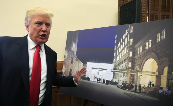 © Reuters. Trump gestures next to an architectural rendering of The Trump Organization's redevelopment of the iconic Old Post Office building into a luxury hotel, in Washington