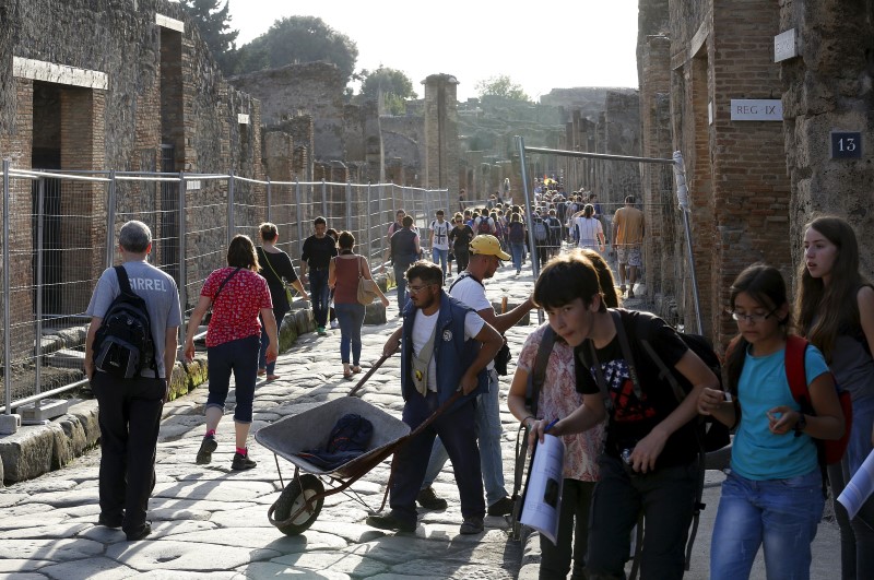 © Reuters. Un operaio a lavoro tra la gente 