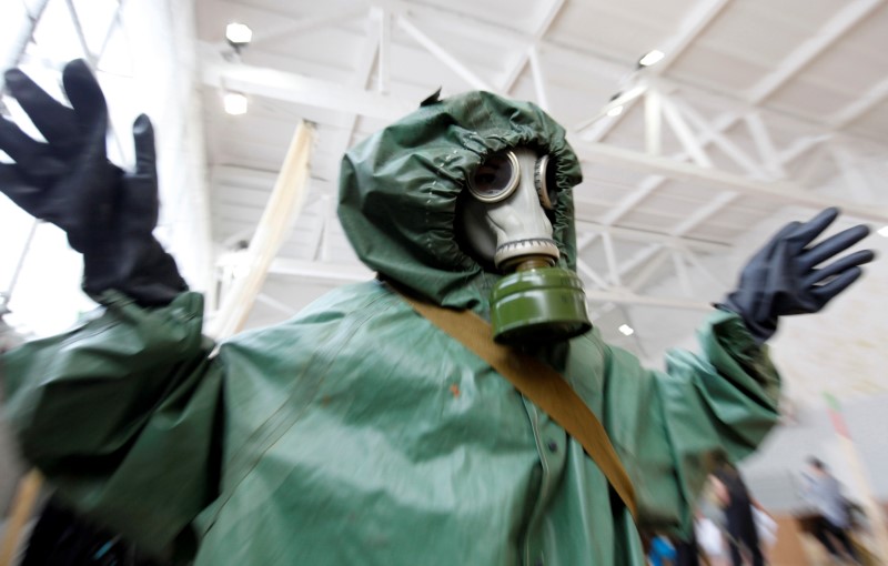 © Reuters. A schoolchild wearing a gas mask and a protective suit participates in a civil defence competition between local schools in Stavropol