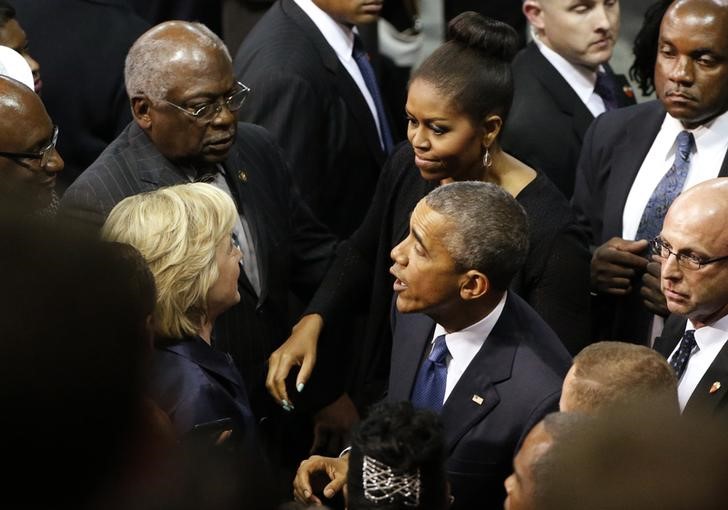 © Reuters. U.S. Democratic presidential candidate Clinton talks with President Obama and the first lady after funeral services for Rev. Clementa Pinckney in Charleston 