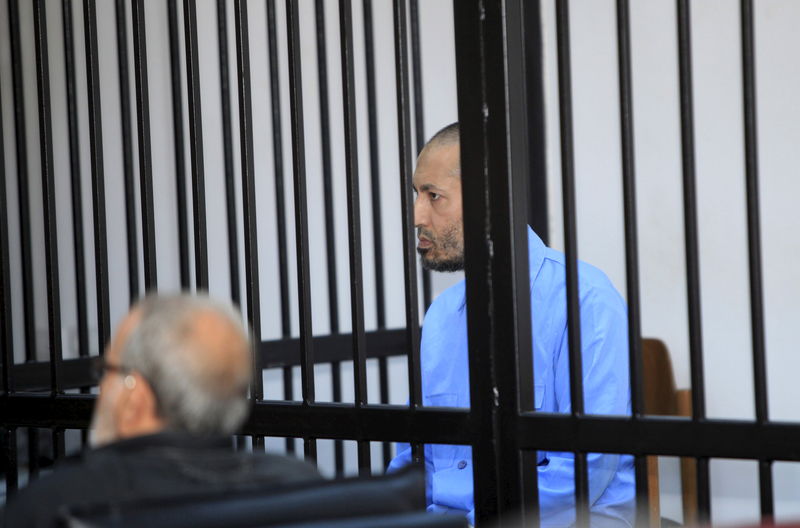 © Reuters. Saadi Gaddafi, son of Muammar Gaddafi, sits behind bars during a hearing at a courtroom in Tripoli, Libya