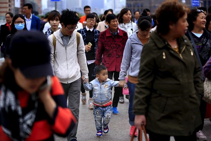 © Reuters. A little boy walks with his parents on a bridge in Shanghai