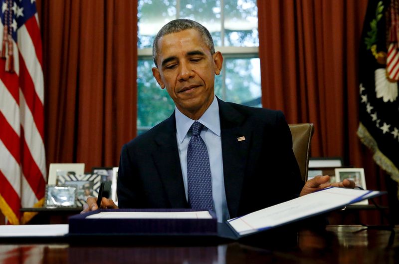 © Reuters. U.S. President Barack Obama closes the folio holding the Bipartisan Budget Act of 2015 after signing it into law in the Oval Office at the White House in Washington