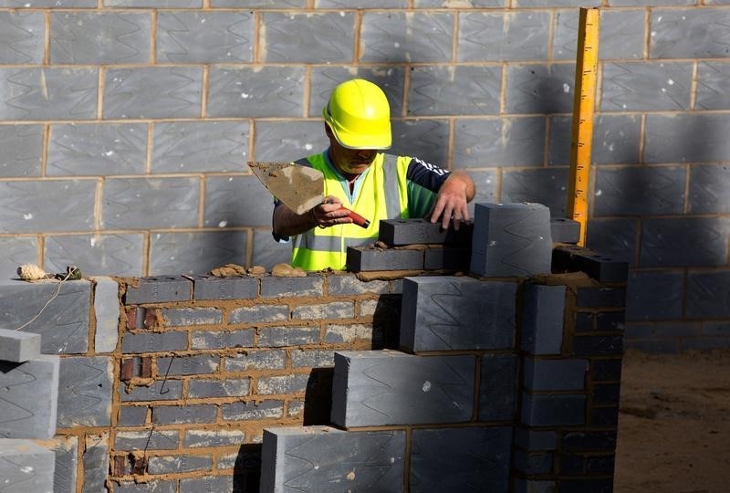 © Reuters. A worker lays bricks for a residential home at a building site in north London