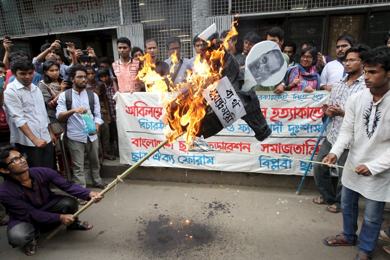 © Reuters. Students of Dhaka University burn an effigy of the Bangladesh Minister of Home Affairs Asaduzzaman Khan at a march in Dhaka