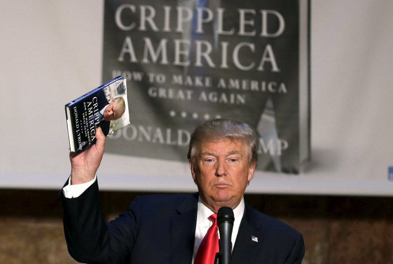 © Reuters. Republican presidential candidate Donald Trump holds up a copy of his new book "Crippled America" at news conference to promote the book in New York