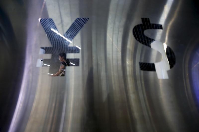 © Reuters. Signs of China's renminbi (RMB) or yuan and U.S. dollar are seen outside at foreign exchange store in Shanghai