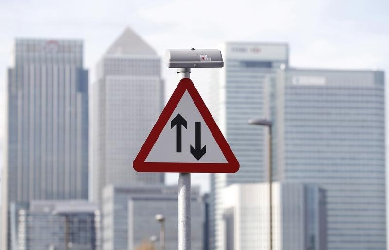 © Reuters. A traffic sign is pictured in front of the skyline of the the Canary Wharf financial district in London