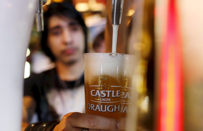 © Reuters. File photo of a barman pouring a beer produced by brewing company SAB Miller at a bar in Cape Town