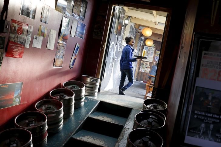 © Reuters. Mulher levando cerveja produzida pela SABMiller, na Cidade do Cabo