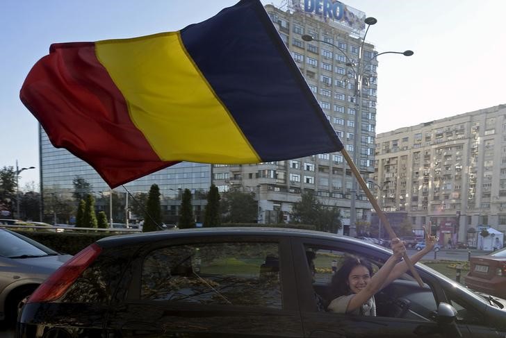 © Reuters. Mulher segura bandeira da Romênia em Bucareste