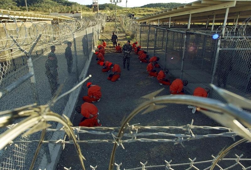 © Reuters. File photo of detainees sitting in a holding area at Naval Base Guantanamo Bay